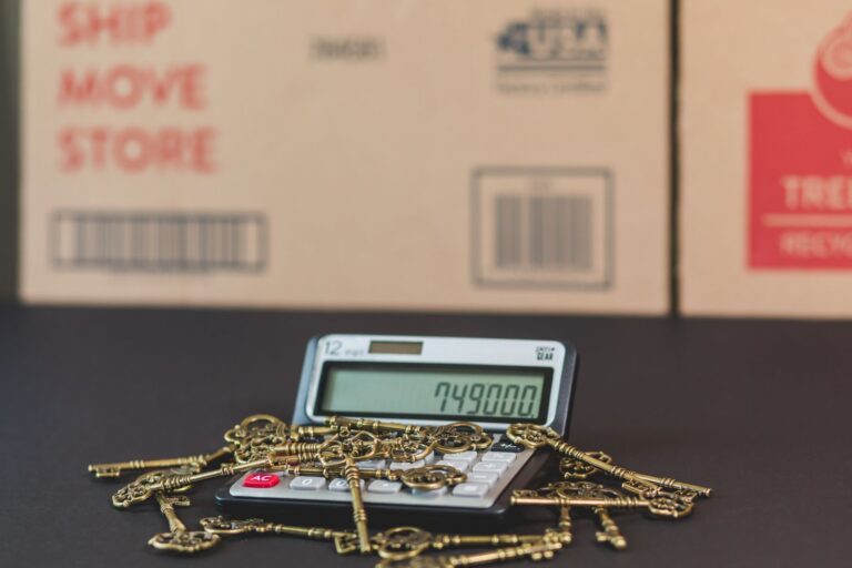 Chei de casă și calculator așezate pe o masă, simbol al bugetării cumpărării unei locuințe