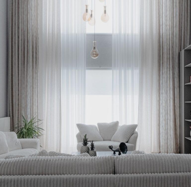 Living luminos amenajat cu canapea deschisă la culoare, covor, plante și mobilier din lemn